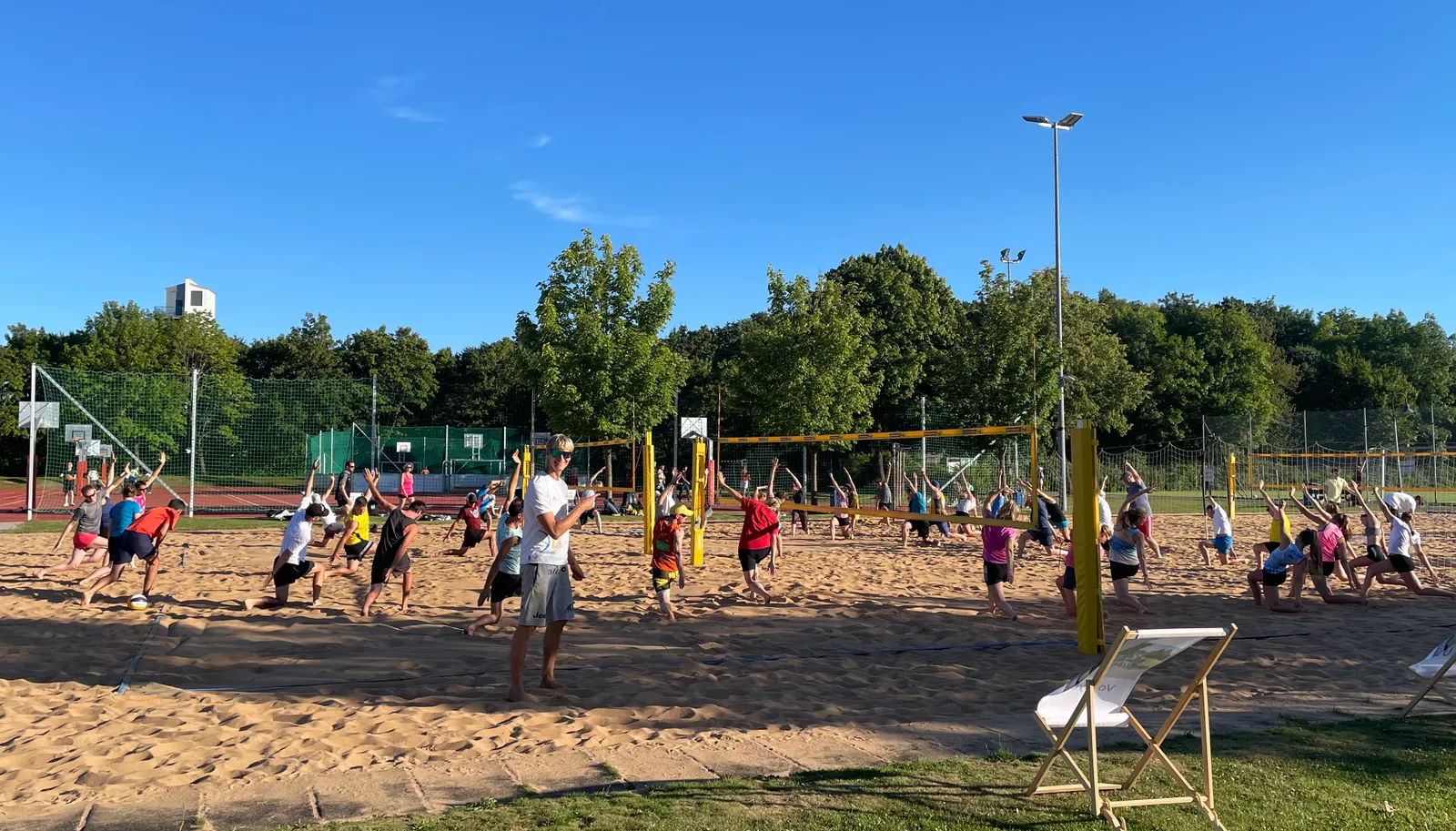 Simon Kulzer betreut ein Firmen-Beachvolleyball-Event mit Team am Sandplatz in München
